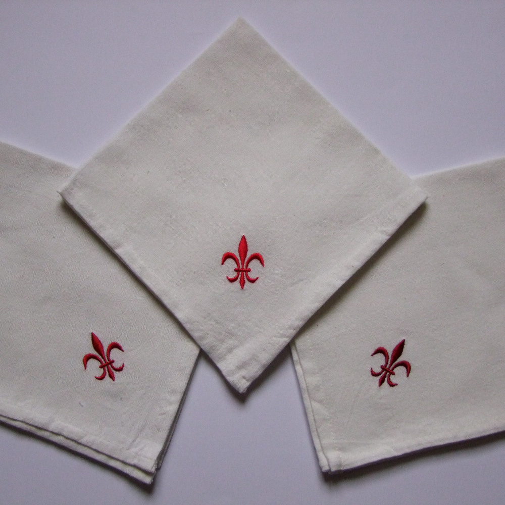 Serviettes de table blanches brodées motif fleur de lys tons rouges