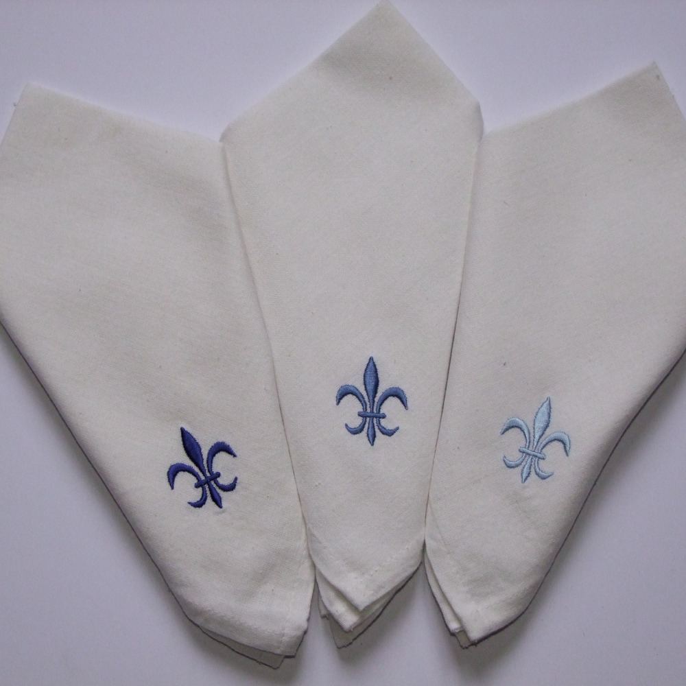 Serviettes de table blanches brodées motif fleur de lys tons bleus